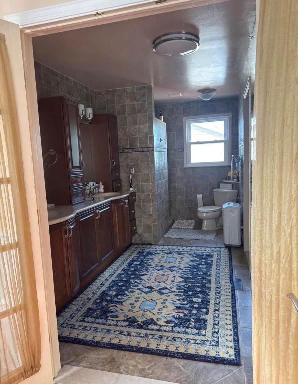 a bathroom with a sink and a toilet and a rug at NinaOCPlace in Ocean City
