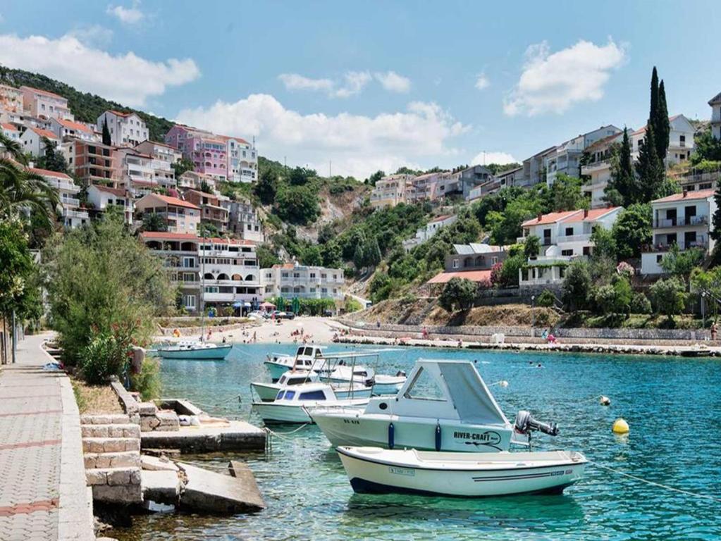 a group of boats docked in a river with buildings at Hotel Villa Matic in Neum