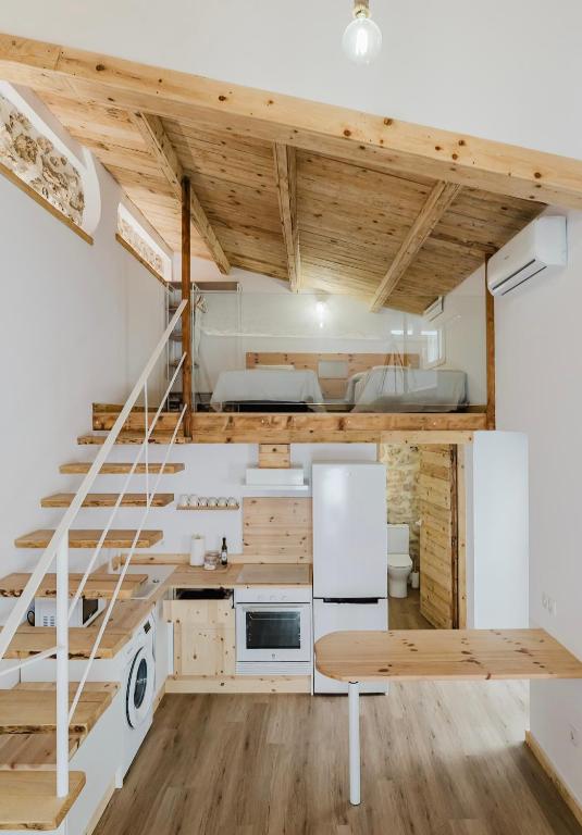a tiny house with a staircase and a kitchen at La cochera by Óscar Fuentes in Alcocer de Planes
