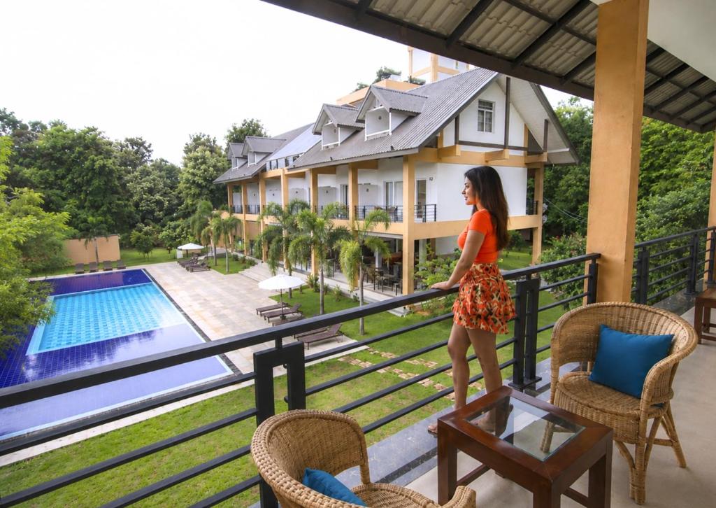 a woman standing on the balcony of a house at Cassandra Culture Resort in Sigiriya