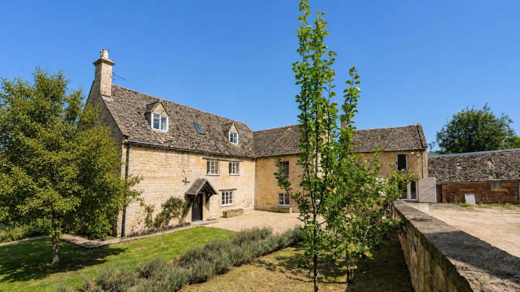an exterior view of a large stone house at Almsbury Farmhouse in Winchcombe
