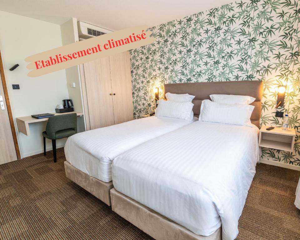 a hotel room with a large bed and a desk at Hotel Restaurant Au Riesling in Zellenberg