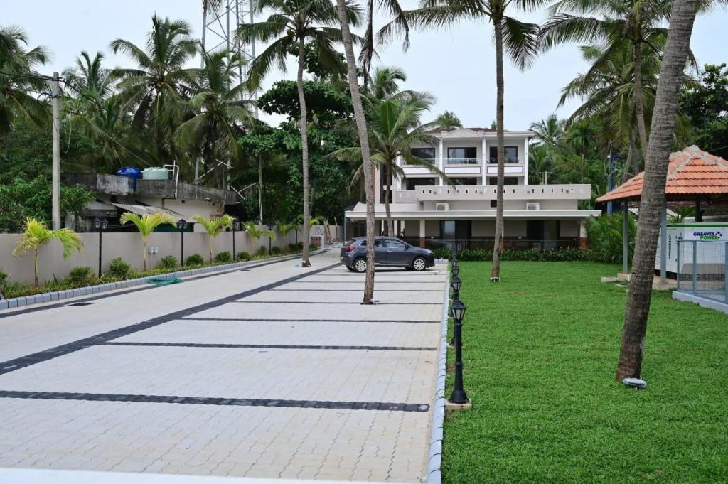ein Auto, das in einer Straße mit Palmen geparkt ist in der Unterkunft Tidal Crest in Kundapura