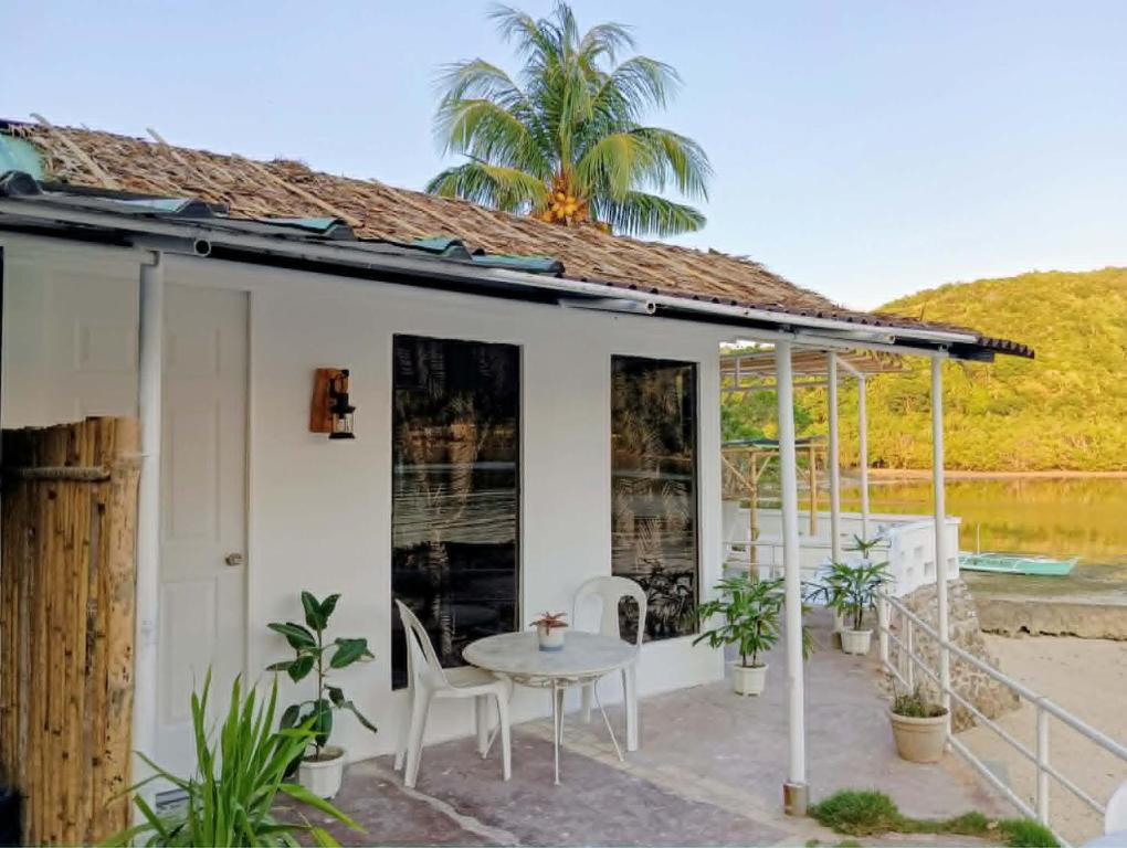 a house with a table and chairs on a patio at Anchor Doods in Romblon
