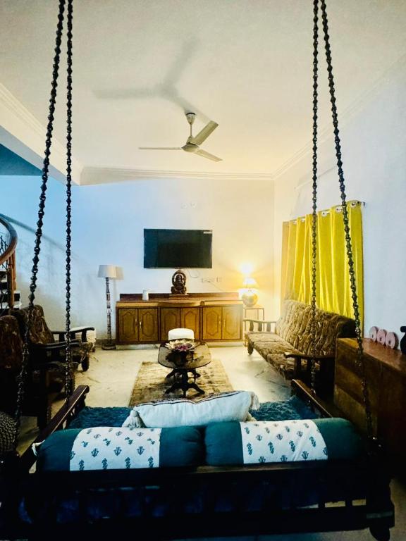 a living room with a hanging bed and a couch at Fernwood stays in Haidar Sāhibgūda
