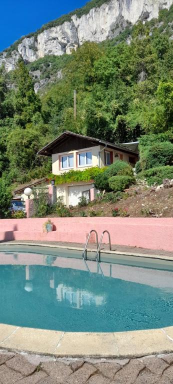 ein Haus und ein Swimmingpool vor einem Berg in der Unterkunft LACUSTRA in Chindrieux