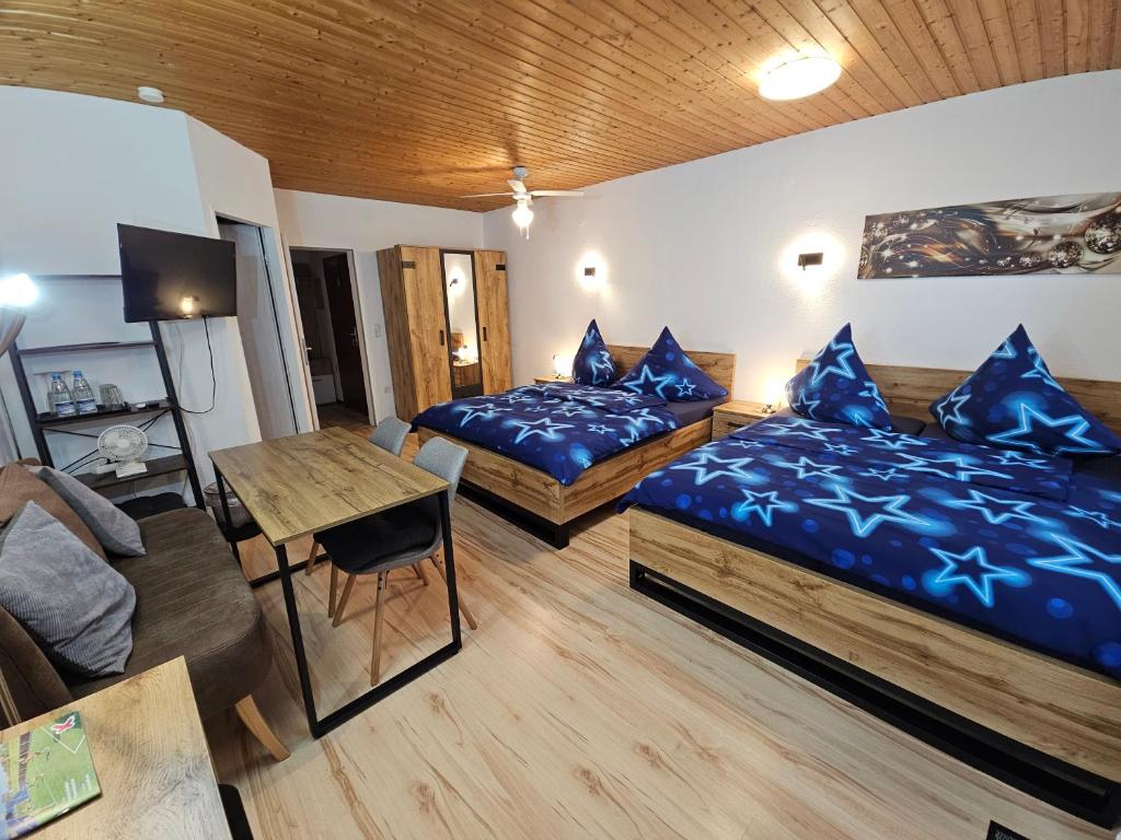 a hotel room with two beds and a table at Pension Haus Erika in Cuxhaven