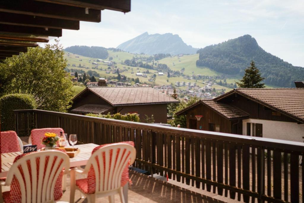 a table and chairs on a balcony with mountains at Apartment Bergdohle in Amden