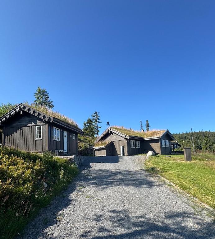 a house with a driveway leading to a building at Vikerfjell i Ringerike, Oslos nærmeste høyfjell in Hønefoss
