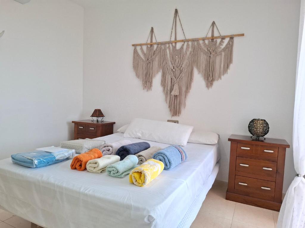a bed with a bunch of pillows on it at Apartamento Playaluna in Almería