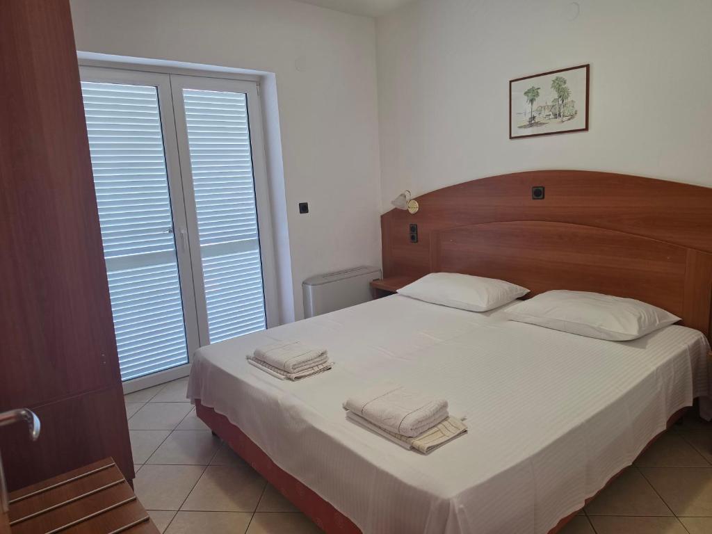 a bedroom with a large bed with towels on it at Apartment Keti - Mandre in Mandre