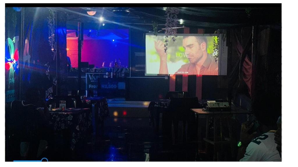 a man on a projection screen in a room at Pandorax Hotel and Lounge in Benin City