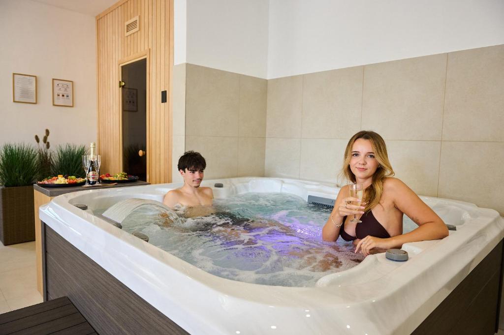 a man and a woman sitting in a bath tub at Hotel Wellness Radnice Dobrovice in Dobrovice