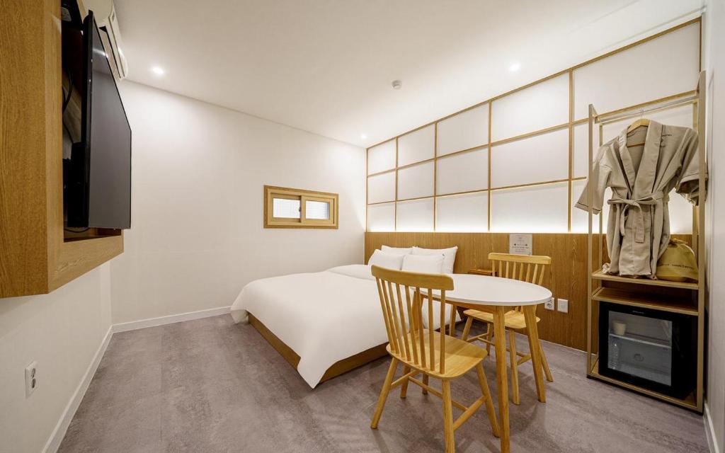 a hotel room with a bed and a table and chairs at Ryokan Hotel The Red Dragonfly in Incheon