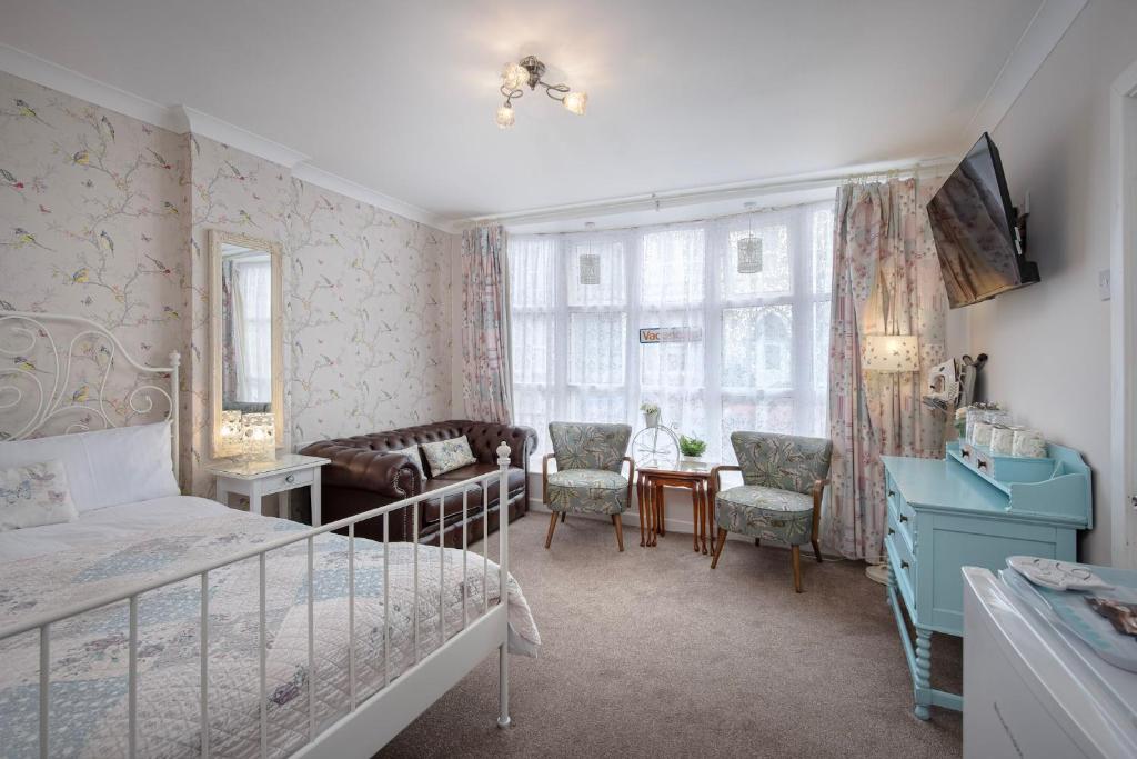 a bedroom with a bed and a table and chairs at The Wescoe Guesthouse in Blackpool