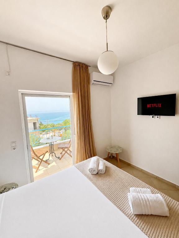 a bedroom with a bed and a view of the ocean at Velmare apartments in Paralia Vrachou