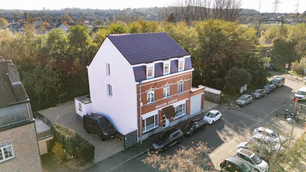 an aerial view of a house with cars parked in a parking lot at Shelter-rooms in Buysinghen