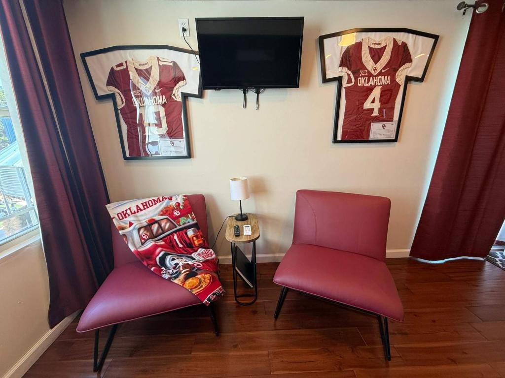 a room with two chairs and a tv and jerseys on the wall at S2 Ft Sill Sky Stack-City View Suite 8-NA PPI SE in Medicine Park