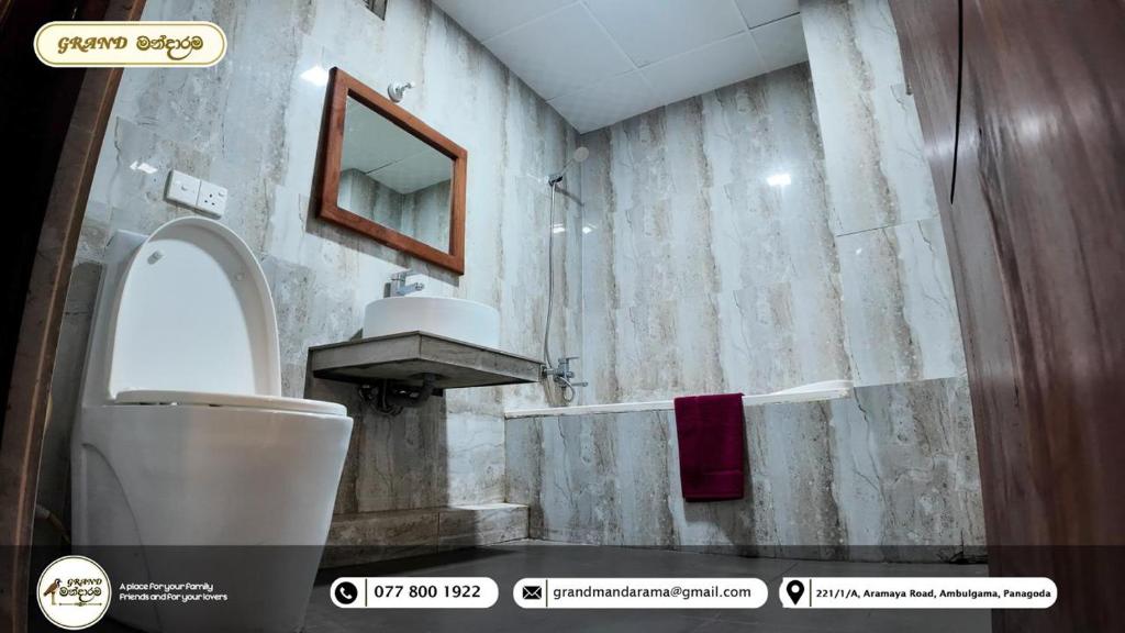 a bathroom with a toilet and a sink at Grand Mandarama Hotel & Resort in Panagoda