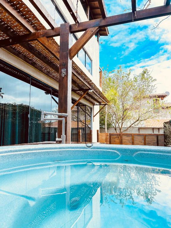 a swimming pool in front of a house at Sheeps Family - Loft, Casa e Apartamento para Temporada - Praia do Rosa in Praia do Rosa