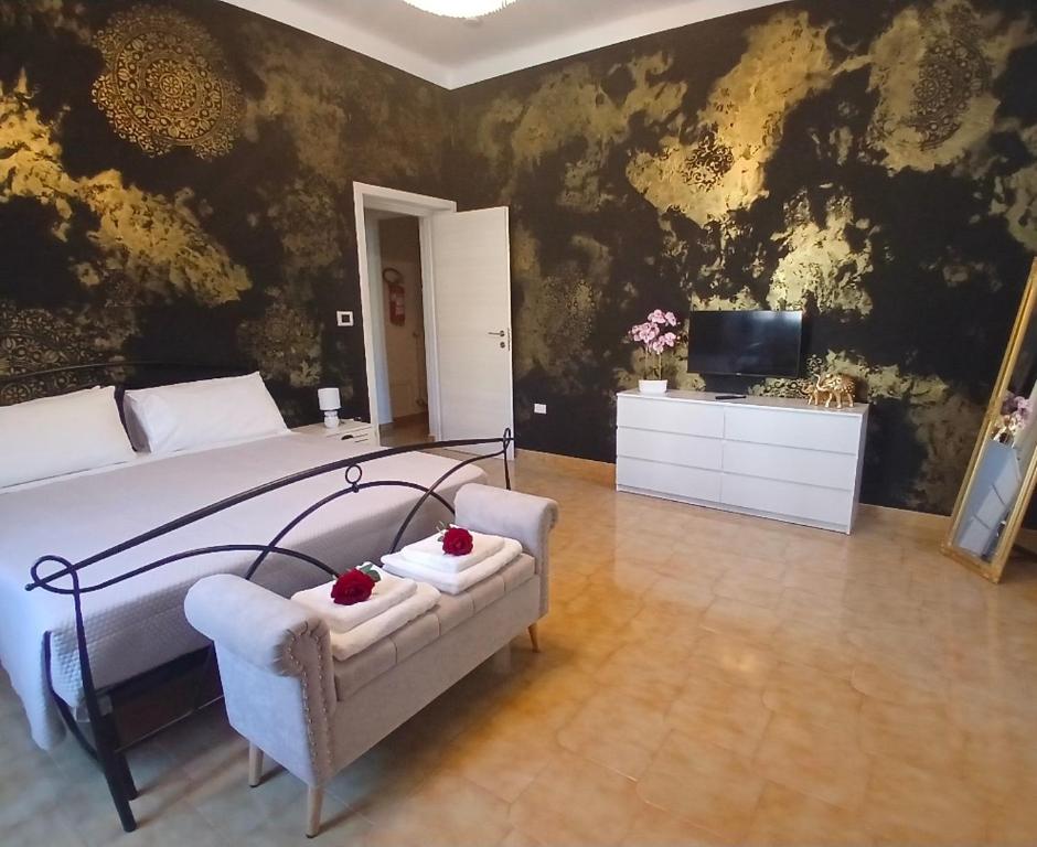 a bedroom with a bed and a chair and a television at Chimera 37 in Avezzano