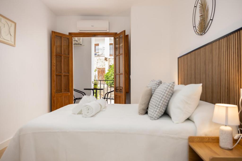 a white bed with white pillows on top of it at Cazorla a tus pies, en pleno centro con parking in Cazorla