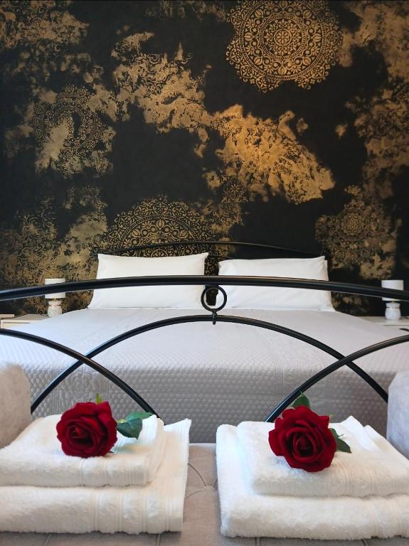 a bed with towels and two roses on it at Chimera 37's in Avezzano