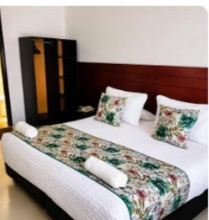 a bedroom with a bed with white sheets and pillows at Hotel Casa Lamay in Bogotá