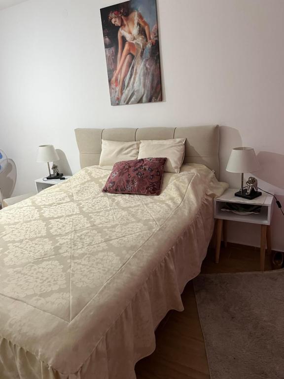 a bed in a bedroom with a painting on the wall at Stan na dan Ub in Ub
