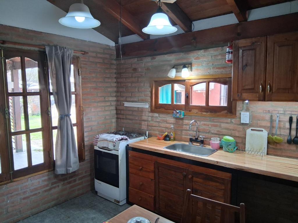 a kitchen with a sink and a stove at Departamentos Don Carlos in Villa Cura Brochero