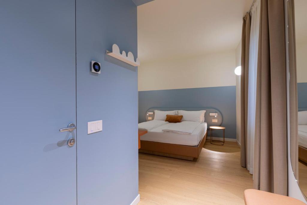 a bedroom with a bed and a blue wall at Borgo di Lazise - Adults friendly in Lazise
