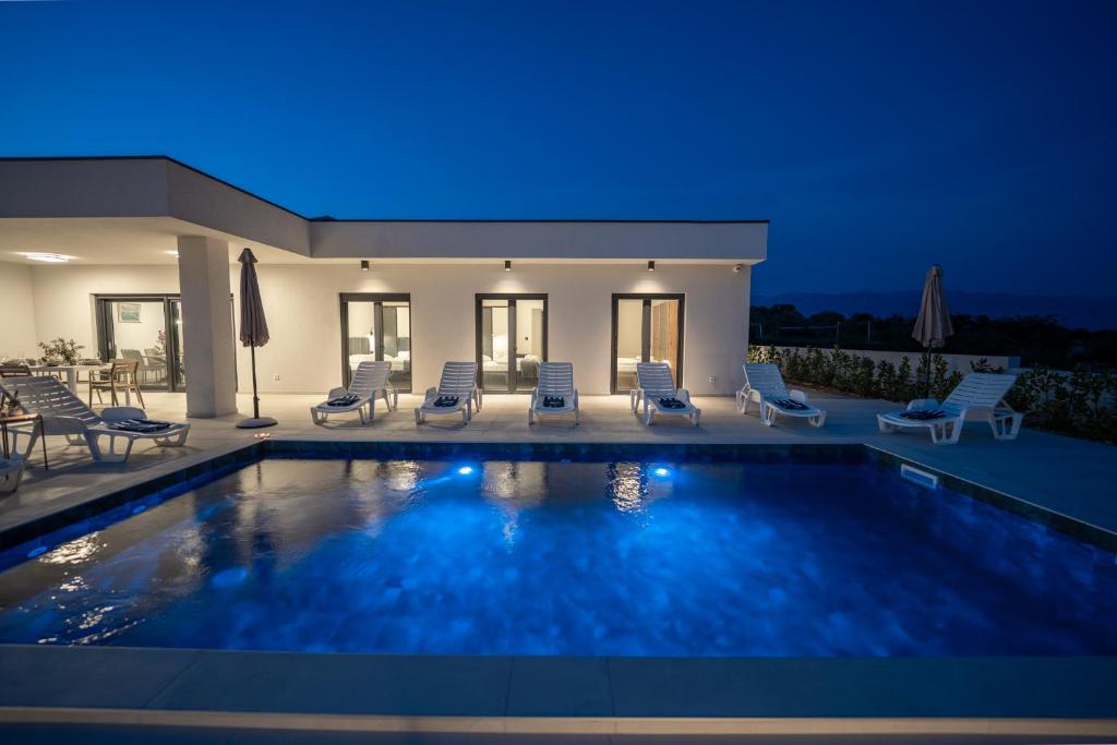 a villa with a swimming pool at night at Villa Meritus in Gramače