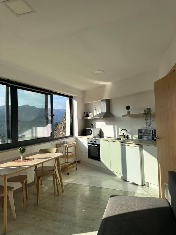 a kitchen with a table and chairs and a kitchen with a view at Lindo Verde T1 in Ventosa