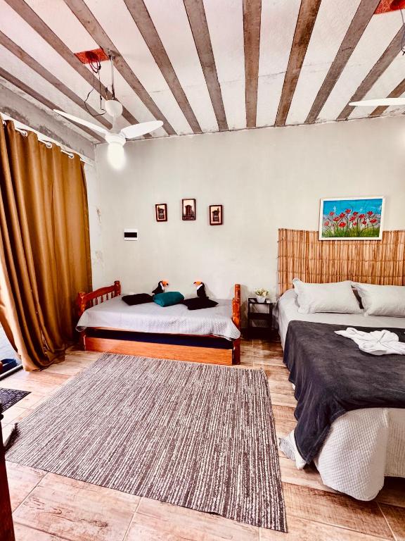 a bedroom with two beds and a rug at Zion Cottage in Paraty
