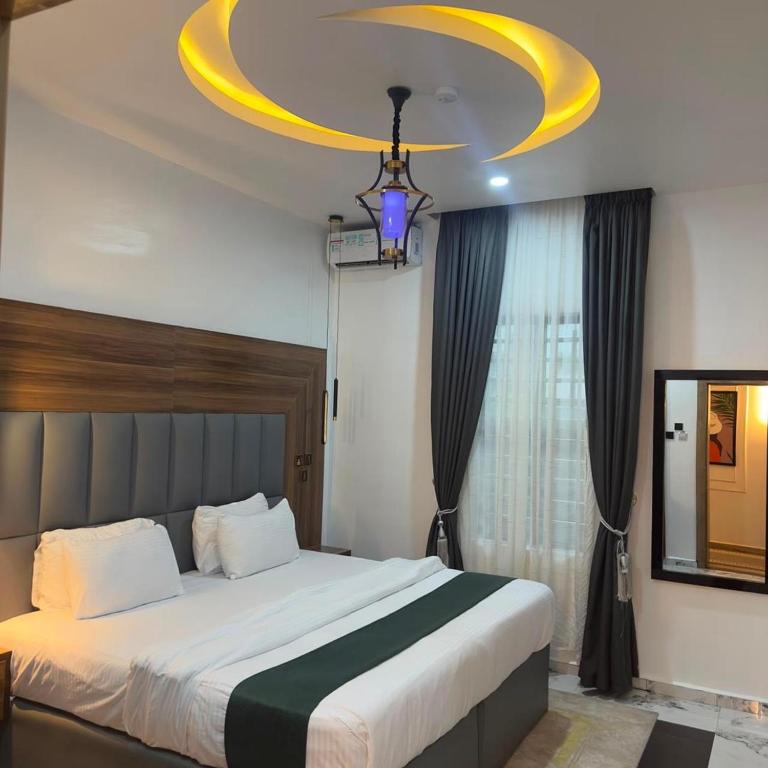 a bedroom with a large bed and a chandelier at Classy Castle Hotel and Suite in Orho Agbarho
