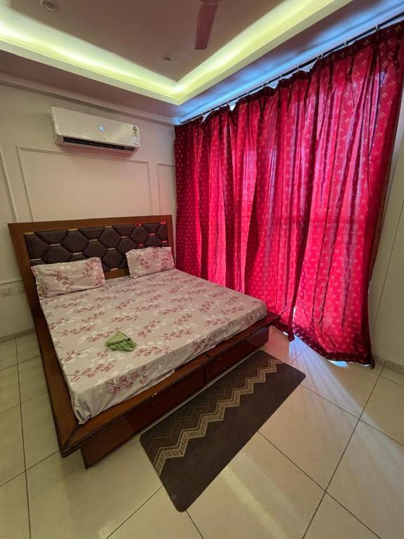 a small bed in a room with a red curtain at Skylines Zirakpur in Zirakpur