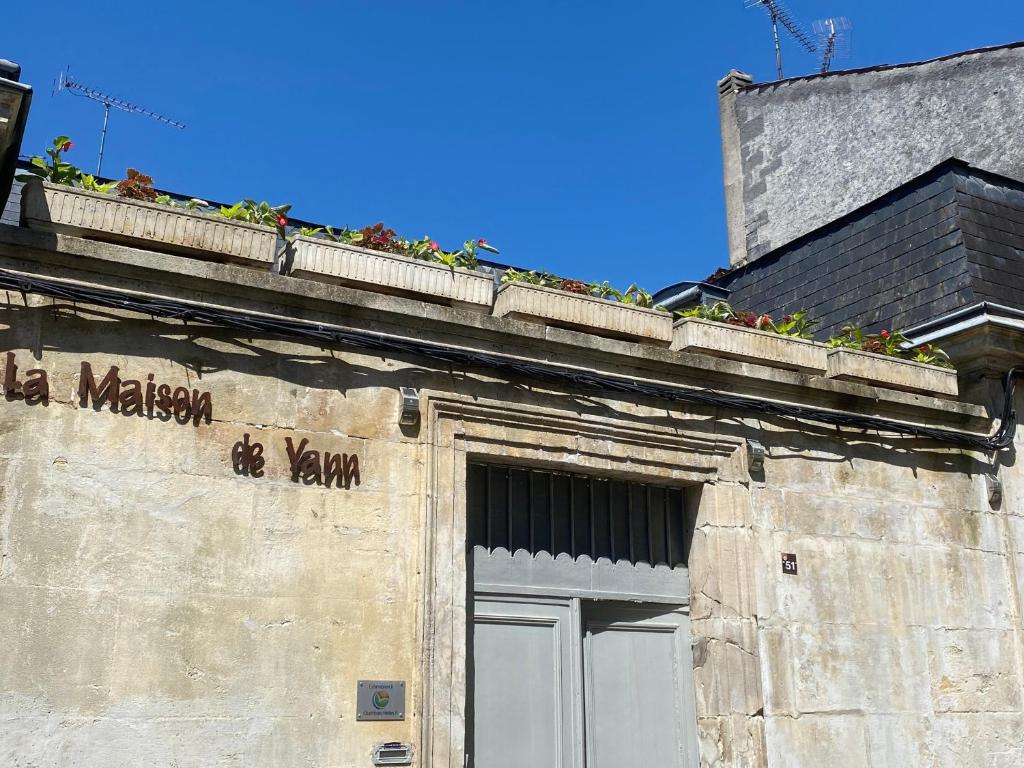 an old building with flowers on top of it at La maison de Yan in Cognac