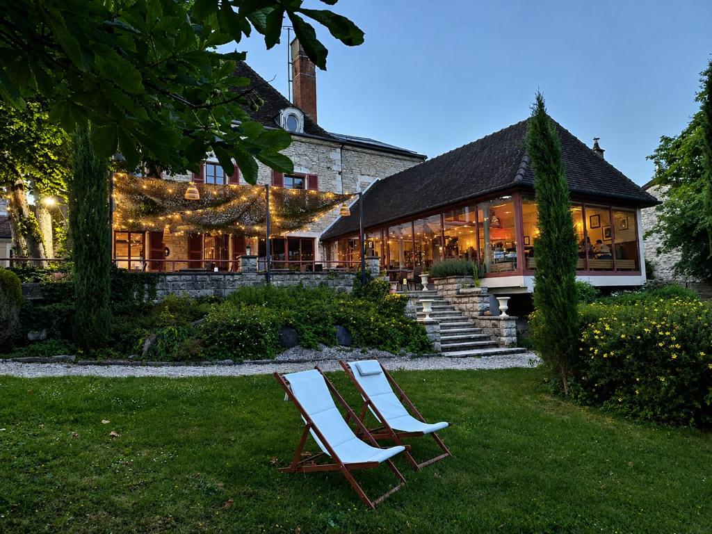 two chairs sitting in the grass in front of a building at Logis Hostellerie la Chaumière in Arsonval