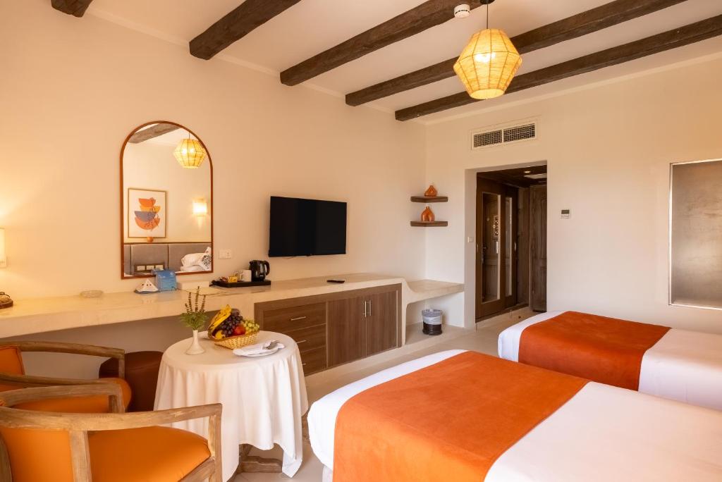 a hotel room with two beds and a table at Shams Alam Beach Resort in Marsa Alam City