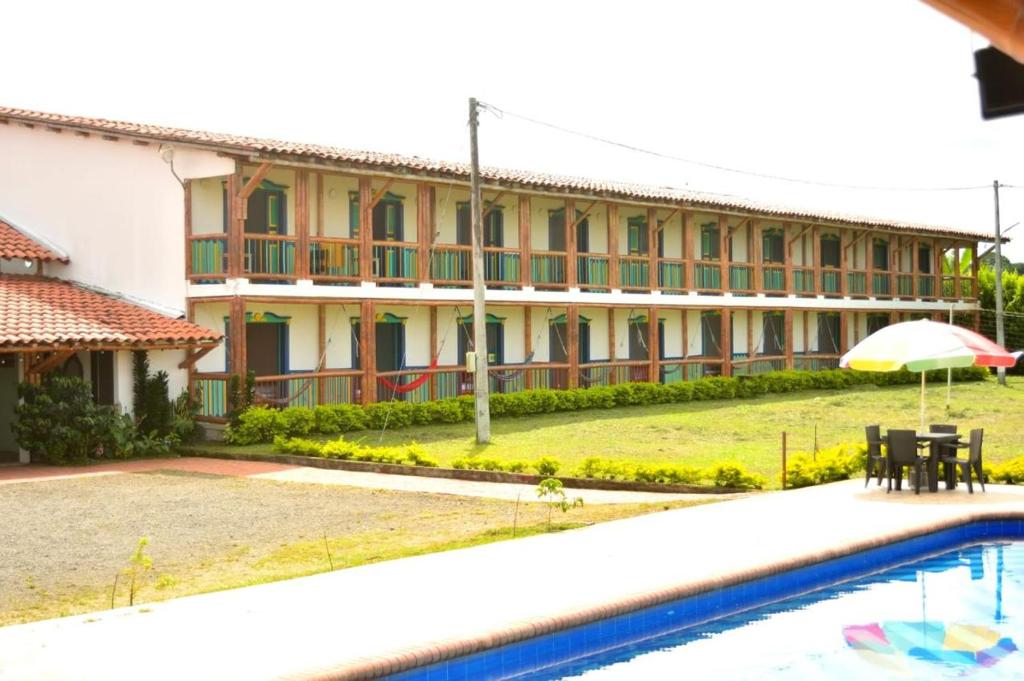 a resort with a swimming pool and a building at Finca Hotel Loma del Café in Pueblorrico