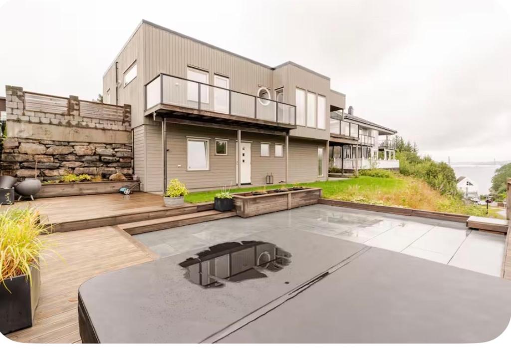 a large house with a patio at Villa with jacuzzi in Nord Bjørøy