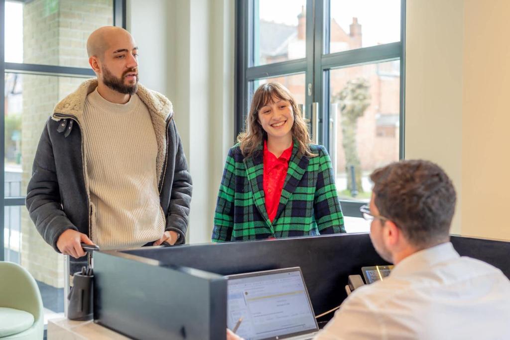 a man and a woman standing in front of a computer at Diff-Rent Studios with gym & Fast Access to Central London & Wembley in Harrow