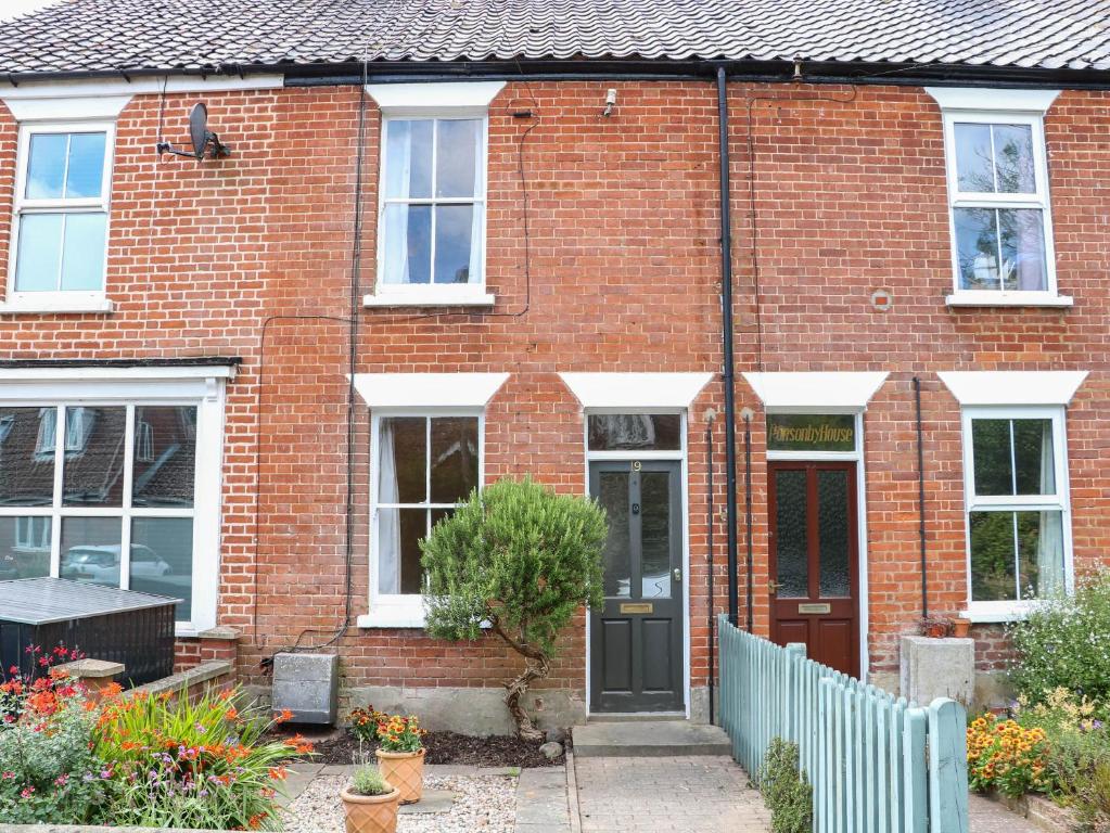 a red brick house with a black door at 19 Covert Road in Southwold