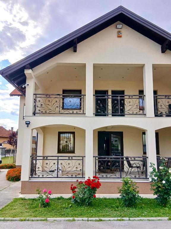 a house with balconies and flowers in front of it at Hajr Villa in Ilidža
