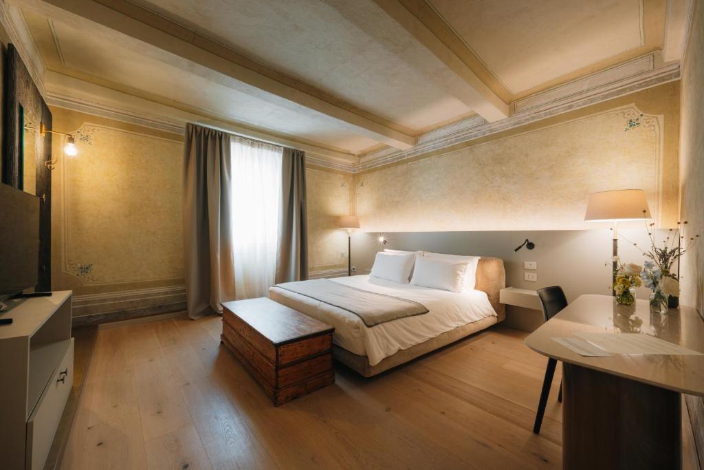 a hotel room with a bed and a television at Palazzo Lucchini in Montalcino
