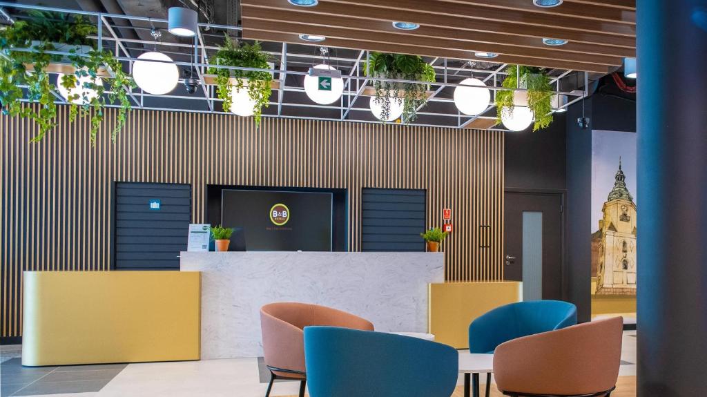 a waiting area with chairs and a table in a lobby at B&B HOTEL Kielce Centrum in Kielce
