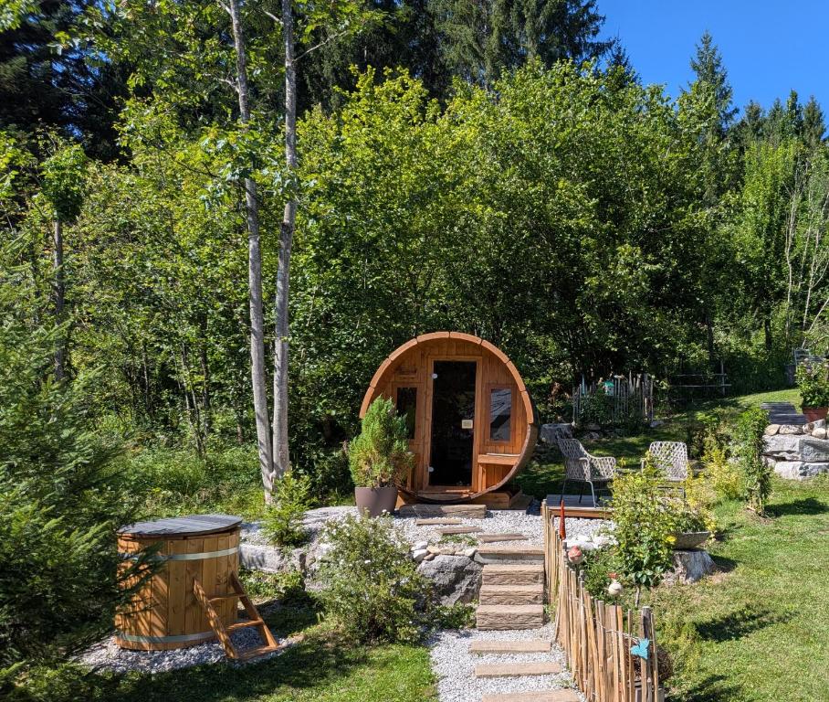 a tiny tree house in a garden with a path at Ferienhaus Lechner am Waldrand mit Holzfasssauna & Außendusche, Bergblick und Naturgarten" in Abtenau