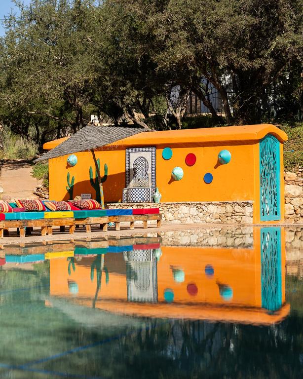 a house in the water next to a pool at Paradis Nomade in Azrarag
