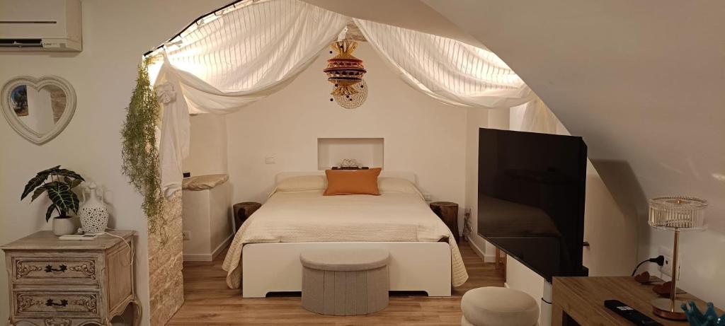 a bedroom with a bed and a flat screen tv at Torre del Fornello in Putignano