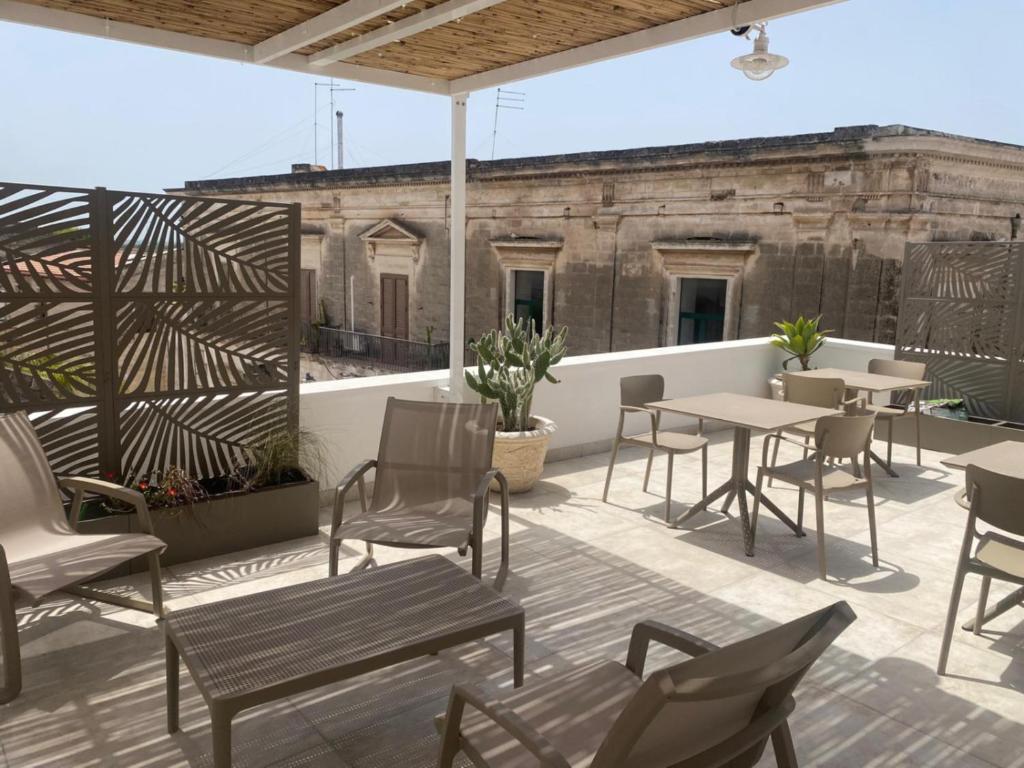 a patio with tables and chairs on a roof at Dietro La Torre in Lizzano